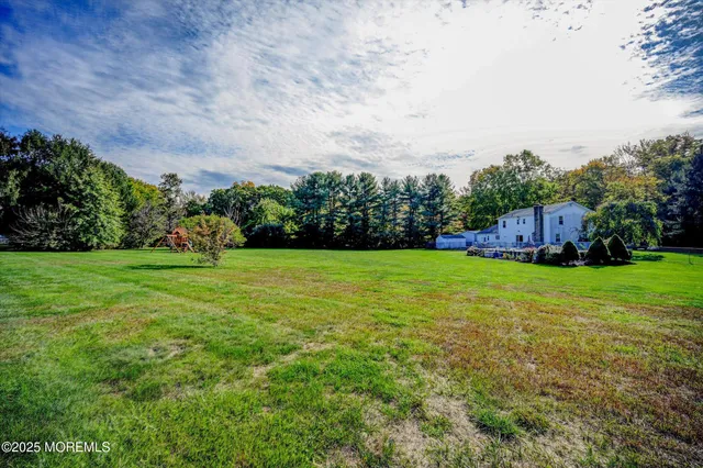 a view of yard with grass & fence
