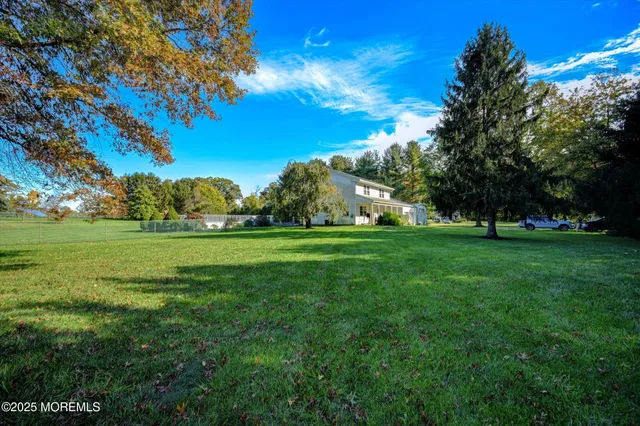 a view of grassy field with benches and trees all around