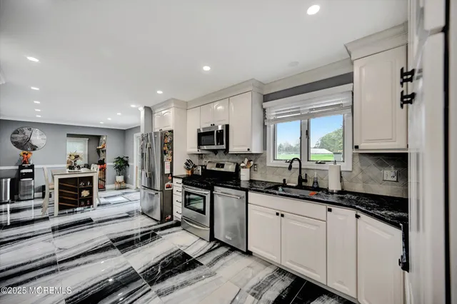 a kitchen with stainless steel appliances a sink stove and cabinets