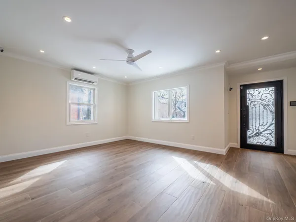 a view of an empty room with window and wooden floor