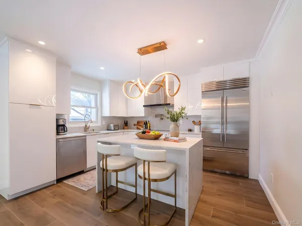 a kitchen with kitchen island a stove a table and chairs in it