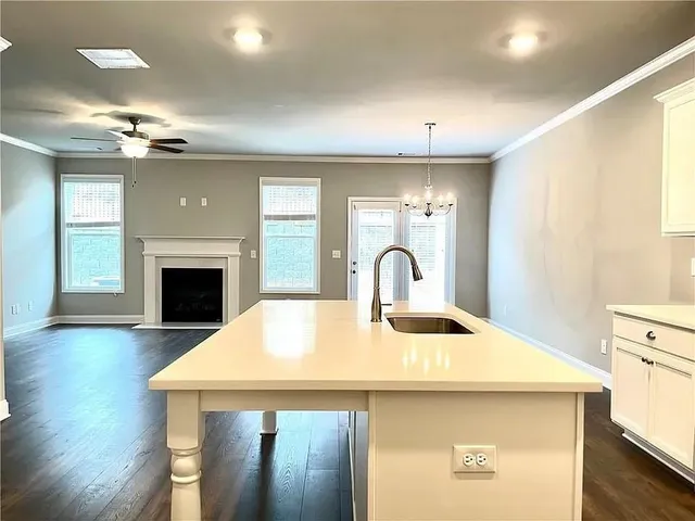 a kitchen with kitchen island a sink appliances and a fireplace