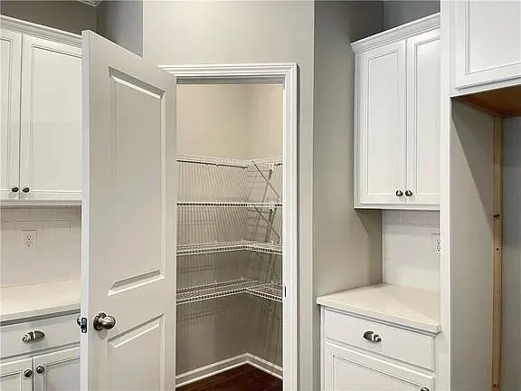 a kitchen with white cabinets and a refrigerator