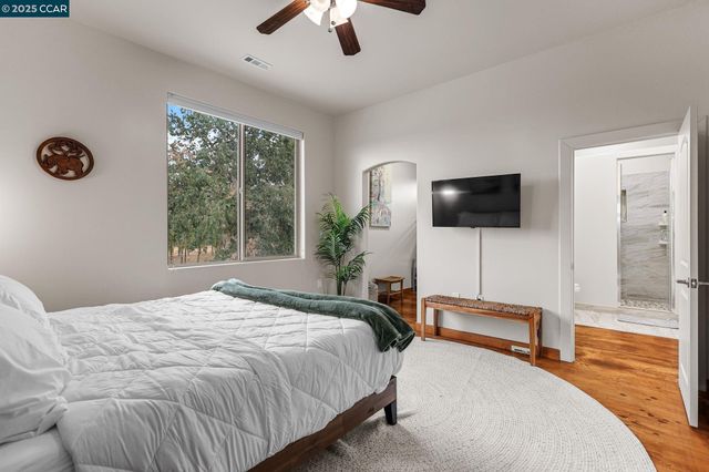 a bedroom with bed tv and window