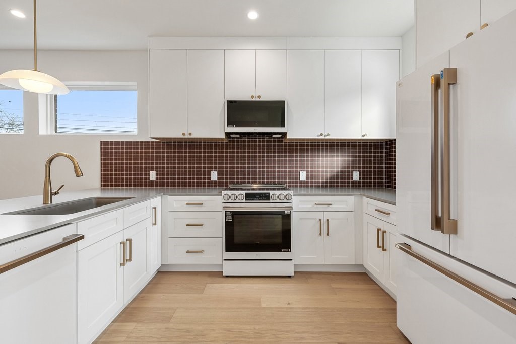 a kitchen with white cabinets and appliances