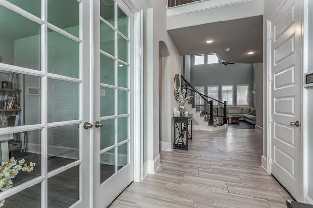a hallway with wooden floor staircase and a living room