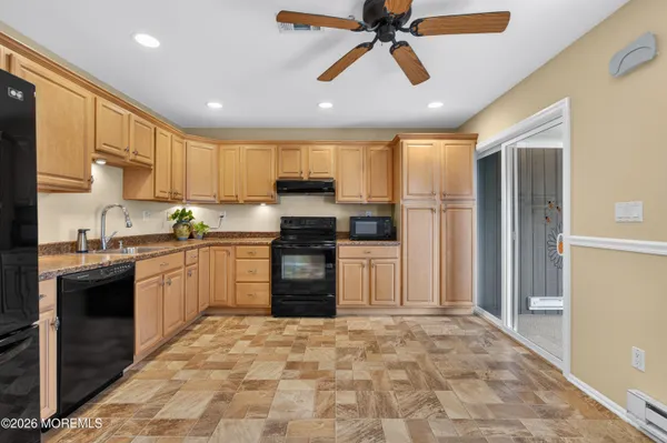 a kitchen with kitchen island a sink a stove a refrigerator cabinets and a counter top space