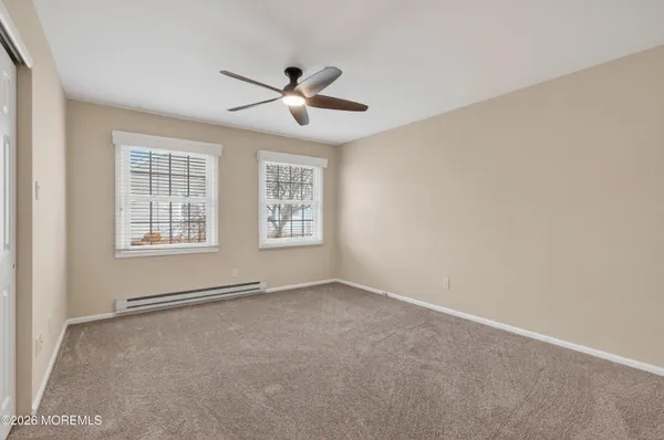 an empty room with windows and fan