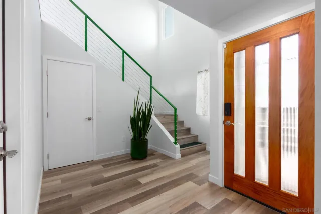 a view of a hallway with wooden floor and a bathroom