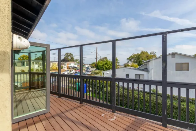 a backyard of a house with a tree and wooden fence