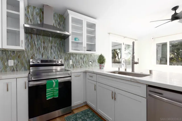 a kitchen with stainless steel appliances granite countertop a sink and a stove