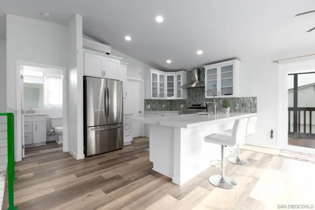 a kitchen with stainless steel appliances granite countertop a refrigerator and a sink