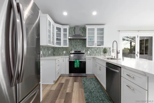 a kitchen with stainless steel appliances granite countertop a refrigerator and a stove