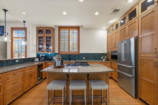 a large kitchen with stainless steel appliances granite countertop a stove a sink and a granite counter tops