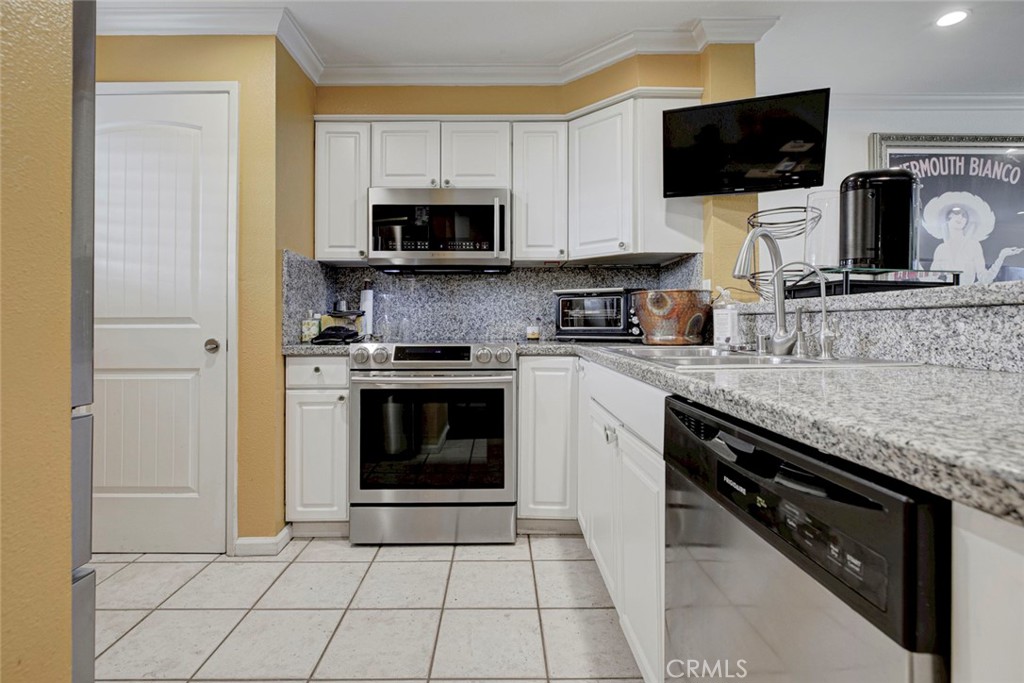 2940 North Verdugo Road, Unit 305 Glendale, CA 91208 - Photo 11 of 26 a kitchen with stainless steel appliances granite countertop a stove microwave and sink