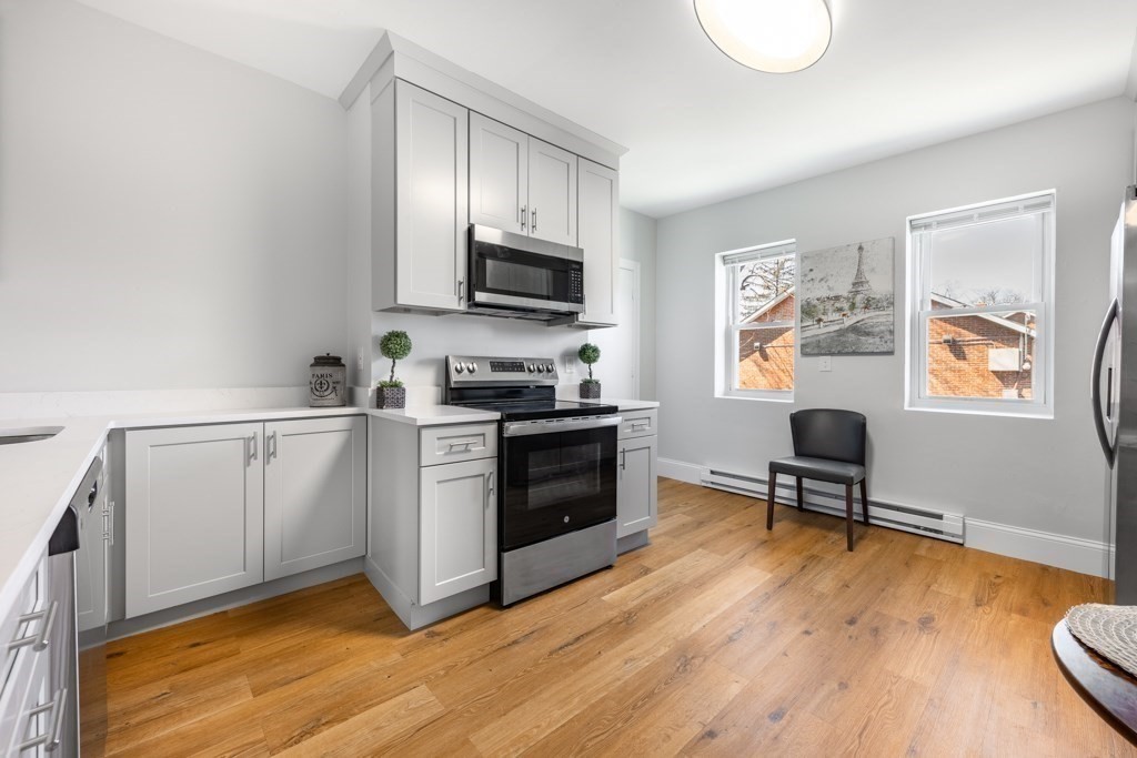 113 Regent Street Boston, MA 02119 - Photo 6 of 18 a kitchen with granite countertop a stove a sink and a refrigerator