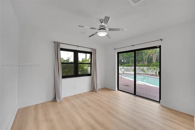 a view of an empty room with wooden floor and closet