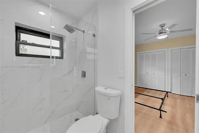 a view of an empty room with a chandelier fan