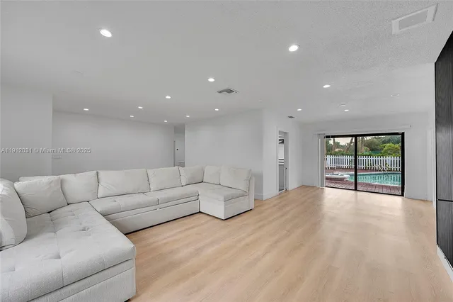 an aerial view of residential houses with outdoor space and trees