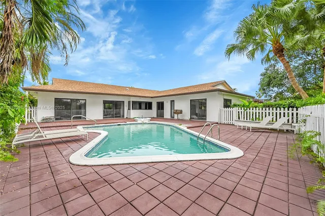 an aerial view of residential houses with outdoor space and trees
