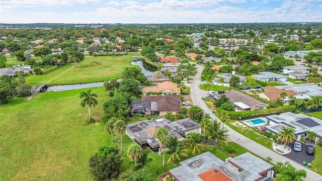 an aerial view of residential houses with outdoor space and trees