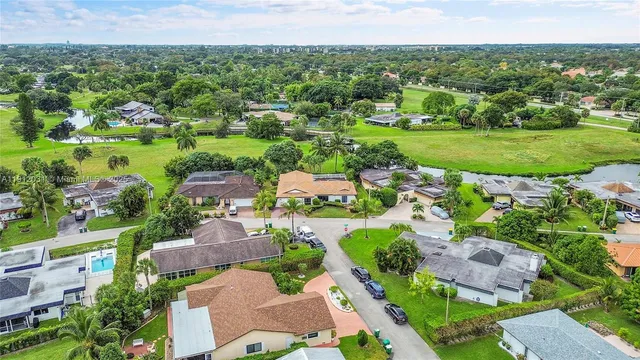 an aerial view of residential houses with outdoor space and trees