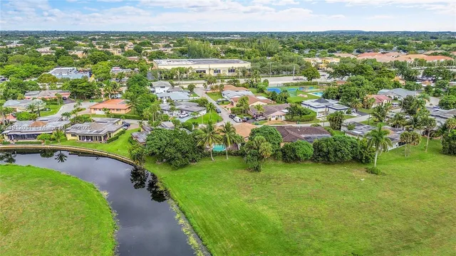 an aerial view of residential houses with outdoor space and trees