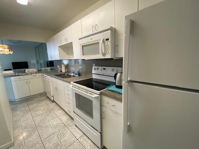 100 Lincoln Road, Unit 616 Miami Beach, FL 33139 - Photo 11 of 31 a kitchen with white cabinets and white appliances