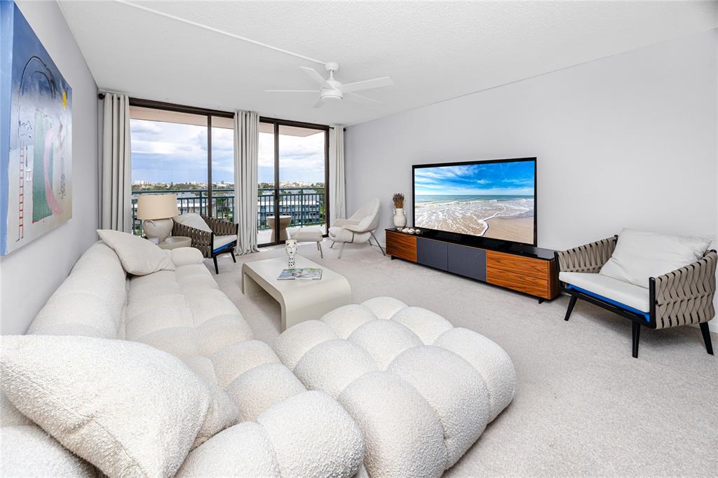 a living room with furniture large window and a flat screen tv
