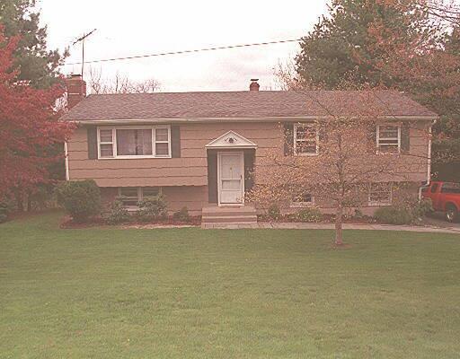 a front view of a house with a garden and plants