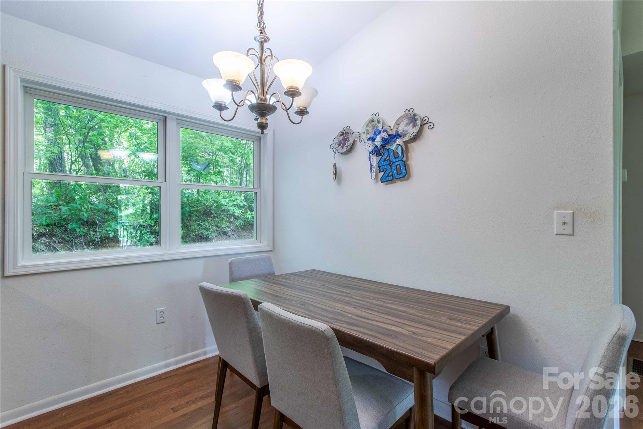 115 Knoll Ridge Waynesville, NC 28785 - Photo 14 of 35 a dining room with wooden floor a chandelier a wooden table and chairs