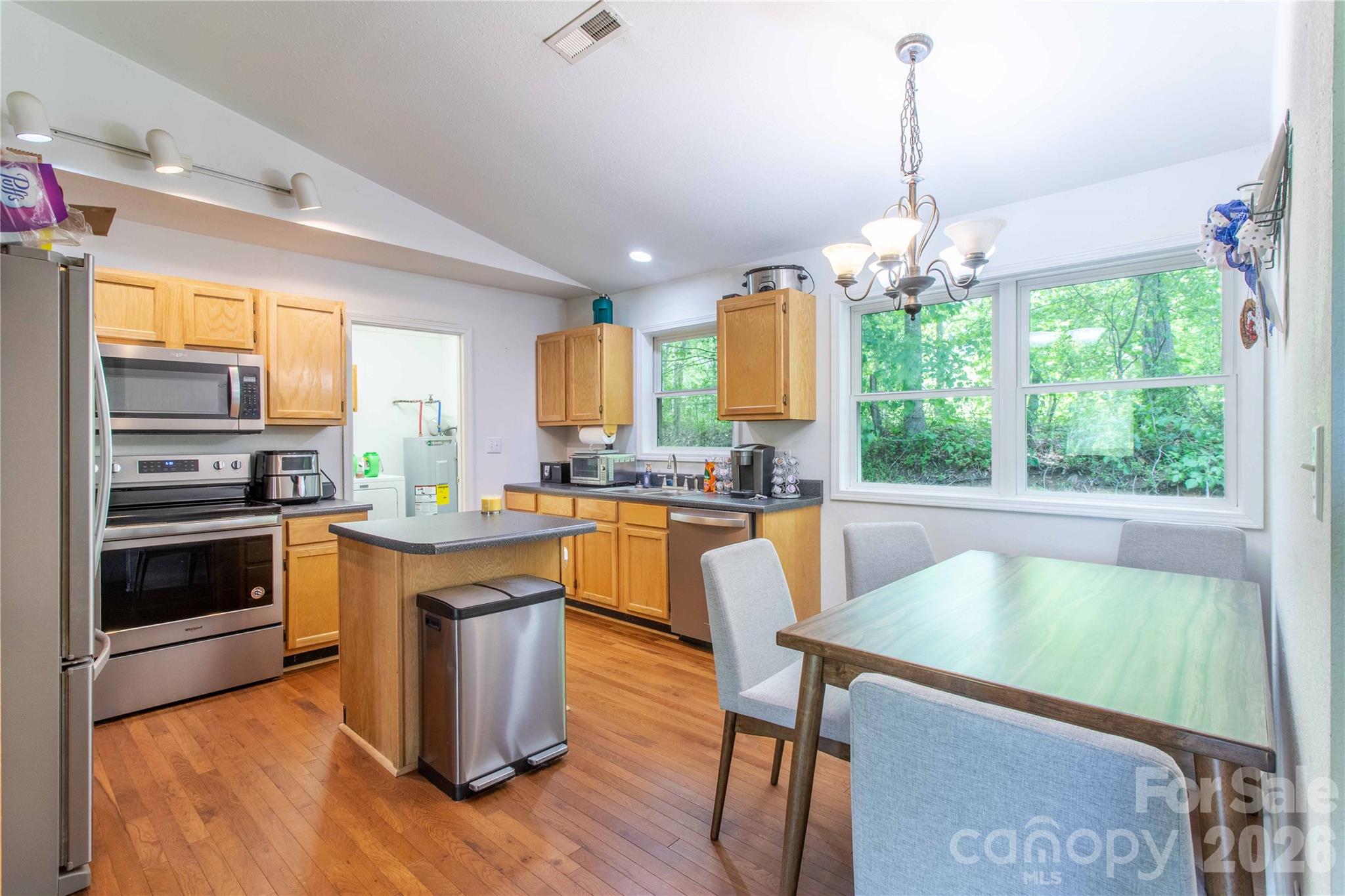 115 Knoll Ridge Waynesville, NC 28785 - Photo 15 of 35 a kitchen with stainless steel appliances granite countertop a stove top oven a sink dishwasher a dining table and chairs with wooden floor