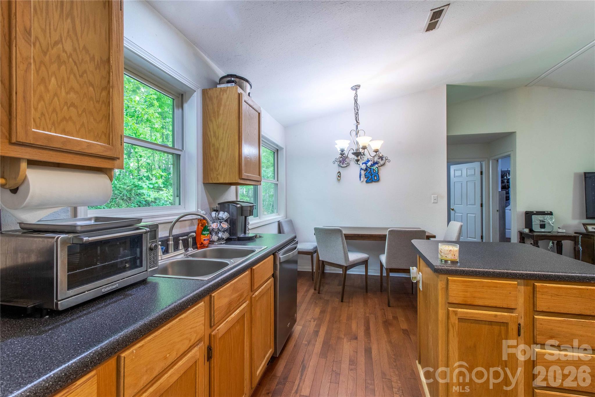 115 Knoll Ridge Waynesville, NC 28785 - Photo 19 of 35 a kitchen with stainless steel appliances a stove a sink dishwasher and cabinets with wooden floor