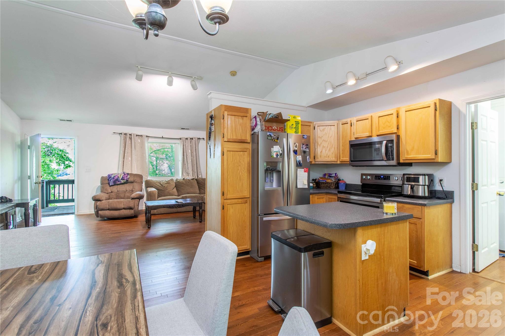 115 Knoll Ridge Waynesville, NC 28785 - Photo 20 of 35 a kitchen with stainless steel appliances granite countertop a refrigerator a stove top oven a sink dishwasher and couches with wooden floor