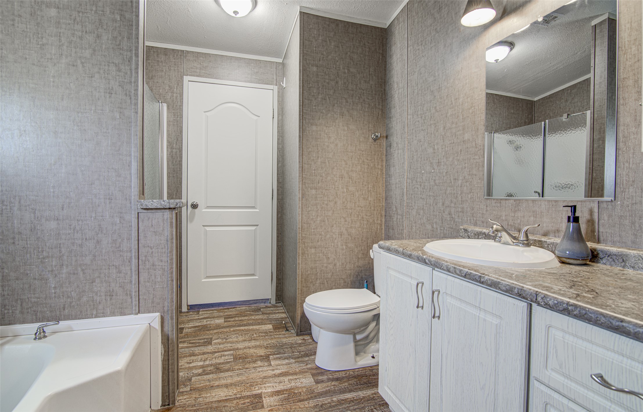 445 Rancho Linda Drive Lockhart, TX 78644 - Photo 18 of 26 A functional primary bathroom offering a vanity with ample storage and a shower-tub combination.