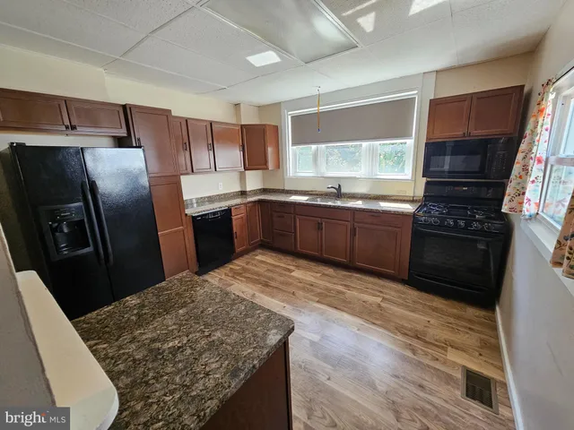a kitchen with stainless steel appliances granite countertop a refrigerator a stove top oven a sink and dishwasher