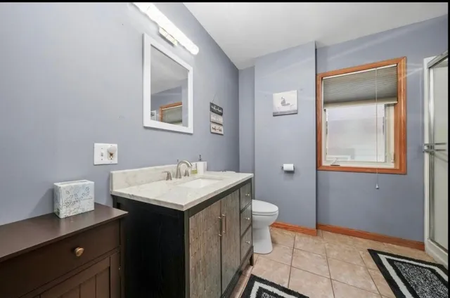 a bathroom with a sink a toilet and mirror