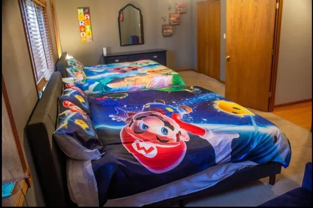 a bedroom with a bed and a lamp on dresser