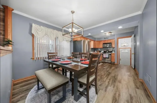 a view of a dining room and livingroom with furniture wooden floor a chandelier