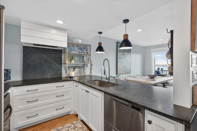 a kitchen with granite countertop a sink and cabinets