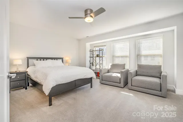 a bedroom with a bed couch and a large window