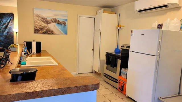 a view of a kitchen with a refrigerator and car parked