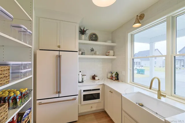 a kitchen with a refrigerator a sink cabinets and a window