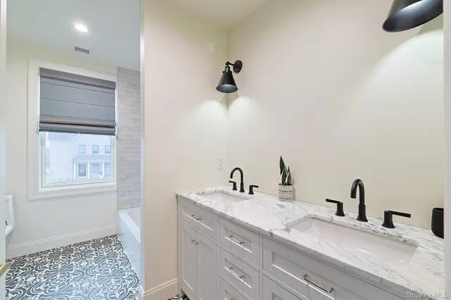 a bedroom with a bed and a flat tv screen on dresser