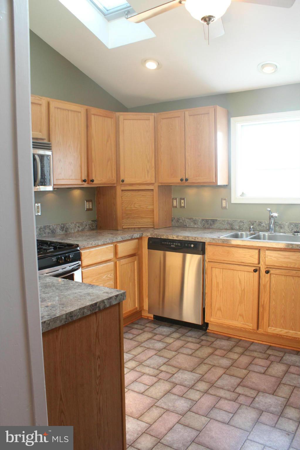 650 North Bend Road Baltimore, MD 21229 - Photo 12 of 22 a kitchen with stainless steel appliances granite countertop a stove a sink and a microwave