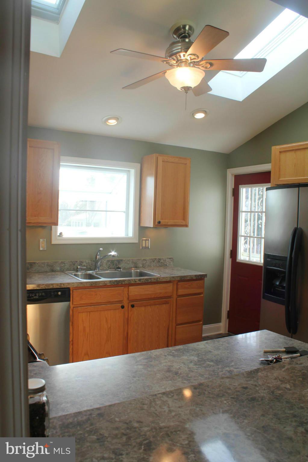 650 North Bend Road Baltimore, MD 21229 - Photo 10 of 22 a kitchen with stainless steel appliances granite countertop a sink dishwasher a stove a dining table and chairs with wooden floor