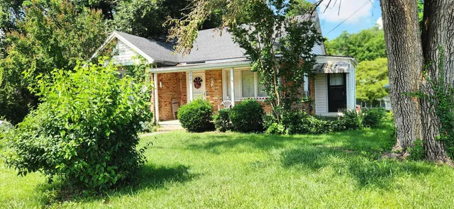 a view of a house with a tree and garden