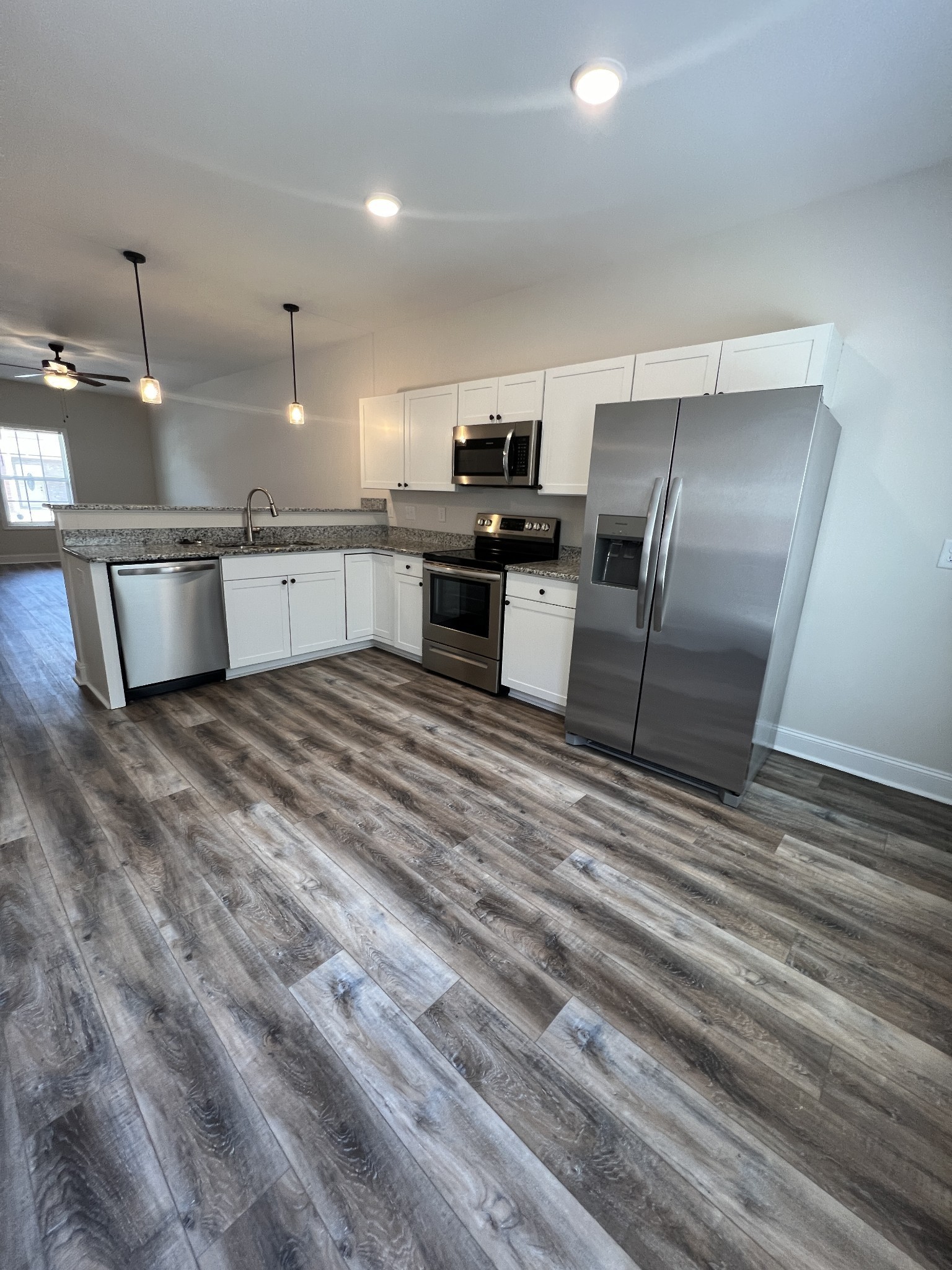 550 Peachers Mill Road, Unit B4 Clarksville, TN 37042 - Photo 7 of 34 a kitchen with stainless steel appliances kitchen island granite countertop a refrigerator and a stove