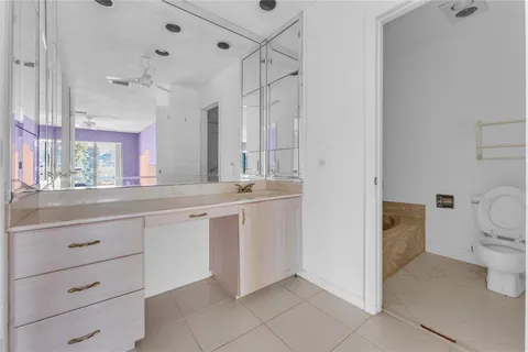 a bathroom with a granite countertop sink mirror and toilet