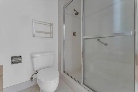 a white toilet sitting next to a shower